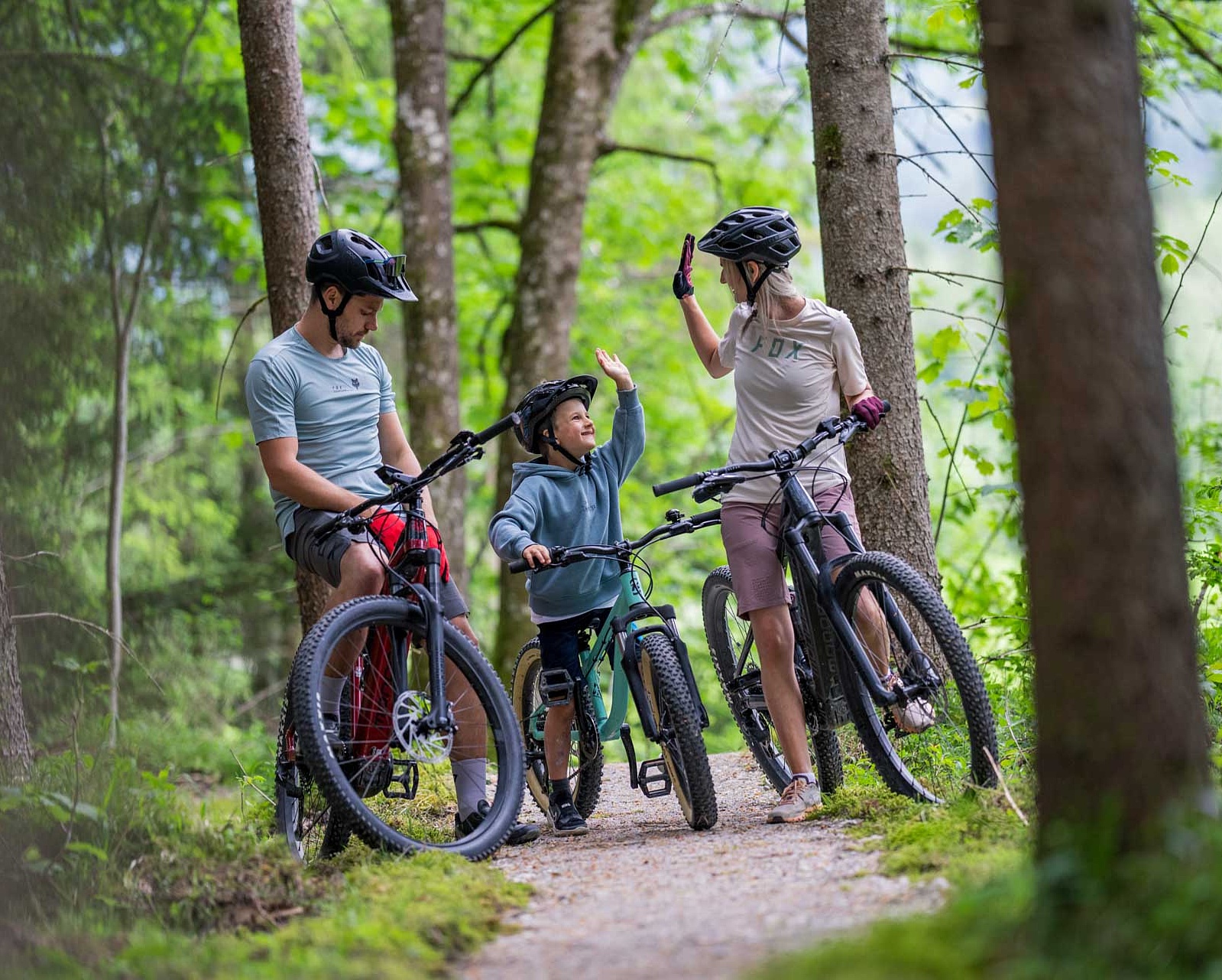 Familie im Wald auf Mountainbikes