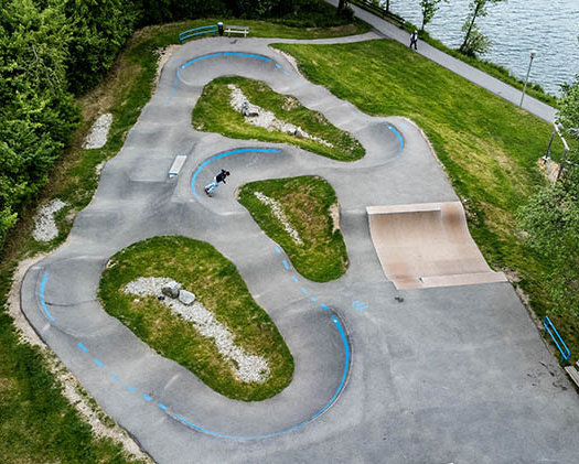 Pumptrack Wackersberg als Luftaufnahme am Seeufer mit asphaltierten Kurven und Wellen